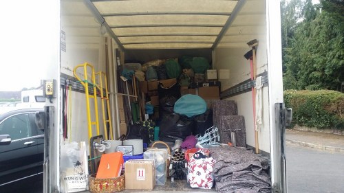 Charity volunteers loading reusable furniture from skip