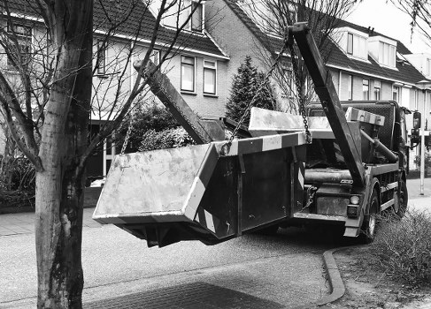 Construction workers loading waste into a skip